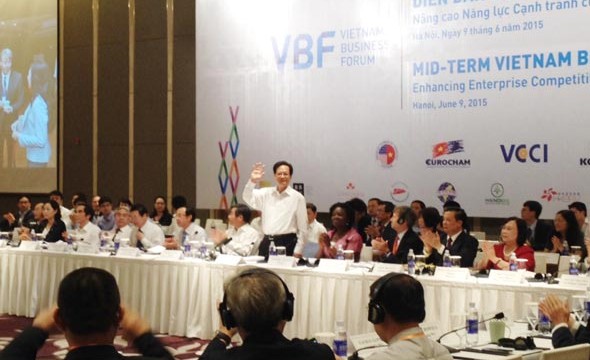 Prime Minister Nguyen Tan Dung (standing) at the 2015 midterm Vietnam Business Forum opened on June 9 (Photo: SGGP)